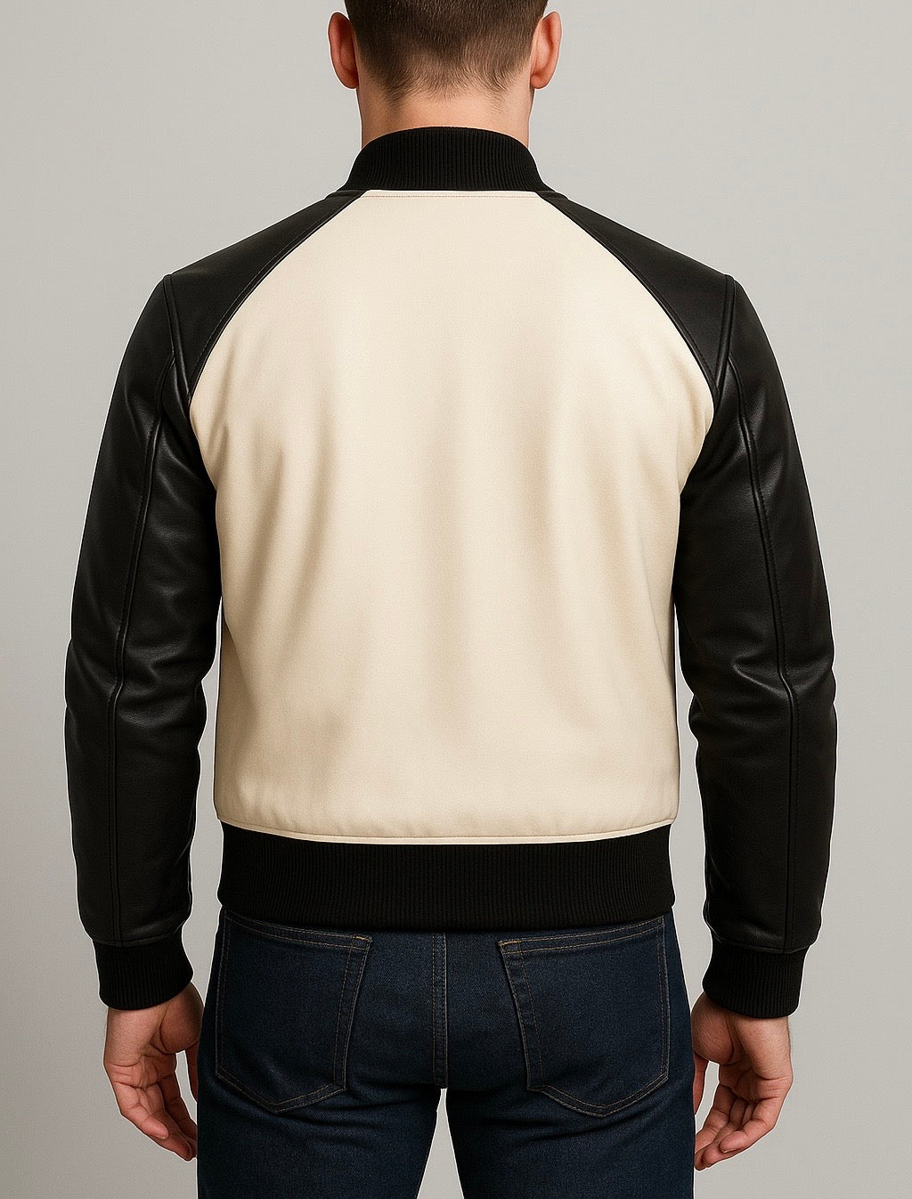 back view of Man wearing a black and beige jacket with leather sleeves on a gray background